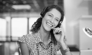 Smiling woman on phone assisting customer