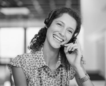 Smiling woman on phone assisting customer