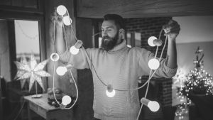 Man holding up a string of holiday lights.